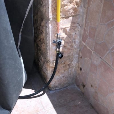 צינור גז צהוב ושחור מחובר לקיר אבן