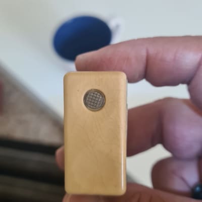 יד מחזיקה רכיב חשמלי עם כפתור עגול