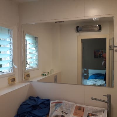 מראה גדולה על קיר חדר אמבטיה