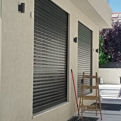 תריסים חשמליים עם סולם וכלי עבודה בחוץ