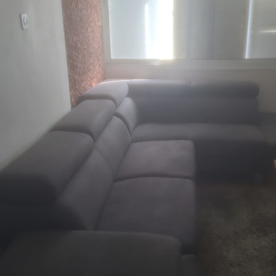 ספה אפורה ליד חלון עם תריסים