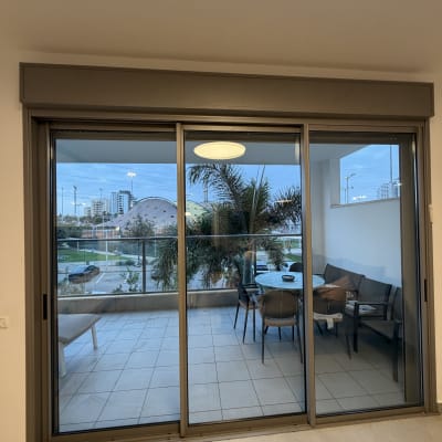 חלון ויטרינה גדול ונקי מזכוכית בדירה המוליך למרפסת