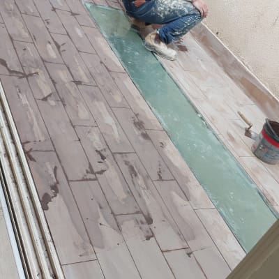 עובד מבצע עבודת איטום על רצפה