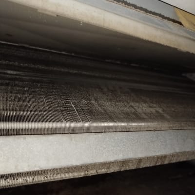 סליל מתכת של מזגן עם לכלוך ואבק