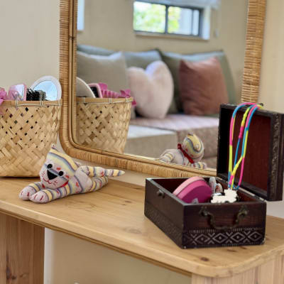 מראה עם סלסלה, קופסה וצעצוע על מדף עץ