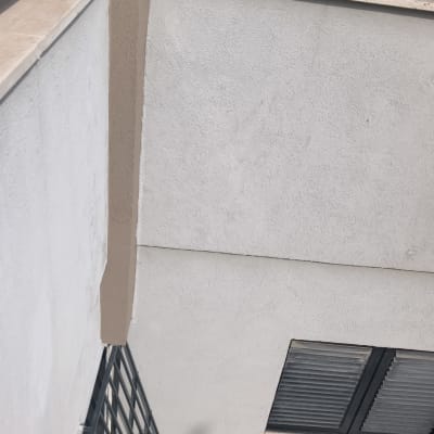 קיר עם מעקה מתכת וחלון עם תריסים