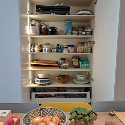 ארון מטבח פתוח עם מדפים מלאים בצנצנות ותבלינים