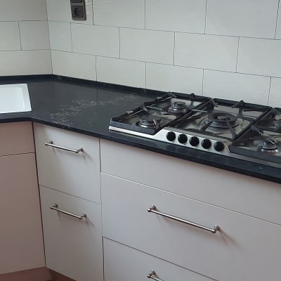 משטח שיש כהה עם כיור וכיריים