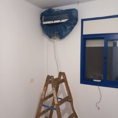 מזגן מכוסה בכיסוי כחול עם צינור ניקוז