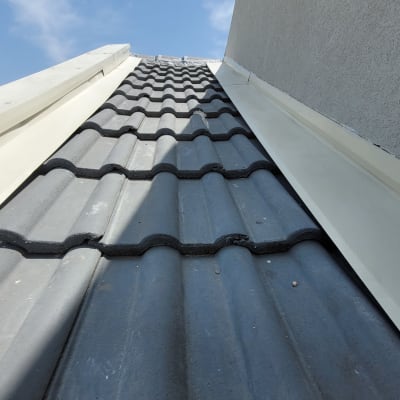 רעפים אפורים על גג עם מסגרת מתכת לבנה