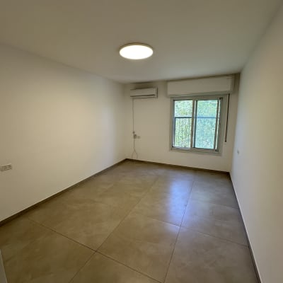 חדר ריק עם רצפת אריחים ותאורה עילית