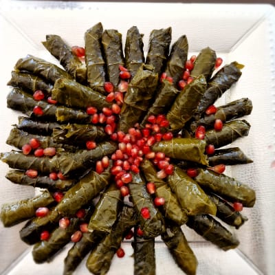 עלי גפן ממולאים עם גרגרי רימון על צלחת