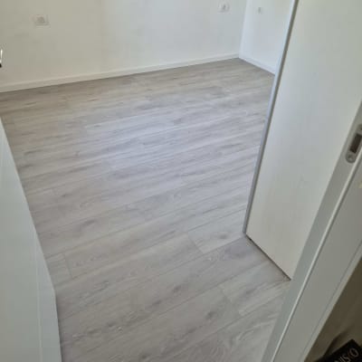 רצפת פרקט עץ בהירה בחדר ריק עם חלון