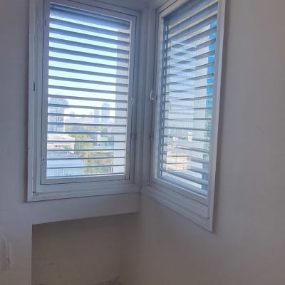 חלון זכוכית עם תריסים בחדר קטן