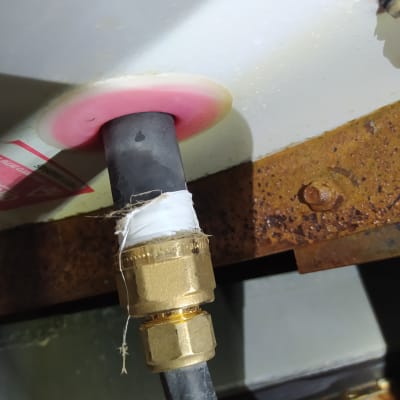 חיבור צינור עם מחבר מתכת על רקע חלוד