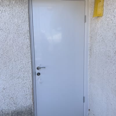 דלת לבנה מותקנת בקיר חיצוני