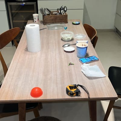 שולחן עם כלים, כוסות, מגבת נייר וסרט מדידה