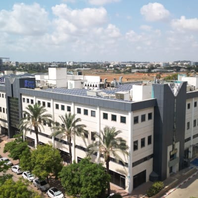 בניין משרדים עם חניה ועצים מסביב