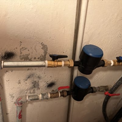 צינורות מתכת עם ברזים ומדי מים כחולים