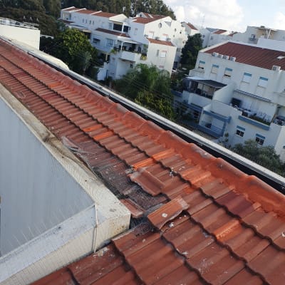 רעפים אדומים על גג עם רשת מתכת