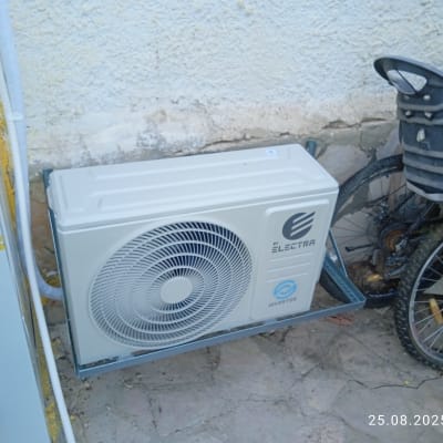 יחידת מיזוג אוויר מותקנת ליד אופניים על קיר חיצוני