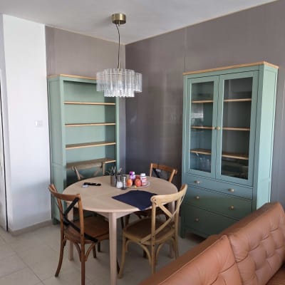 פינת אוכל עם שולחן עגול וכיסאות, ארונות ירוקים