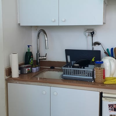 מטבח עם ארונות לבנים וכיור נירוסטה