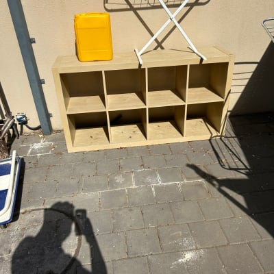 מדף עץ עם מיכל צהוב ומתקן ייבוש בגדים