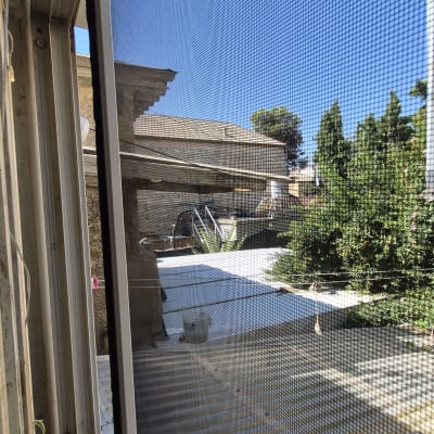 רשת אלומיניום נגד חרקים המותקנת בחלון הזזה
