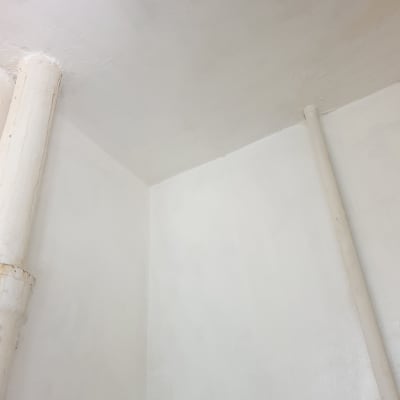 קירות ותקרה צבועים בלבן עם צינורות