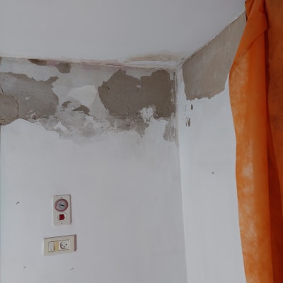 קיר עם טיח מתקלף ותיקוני צבע