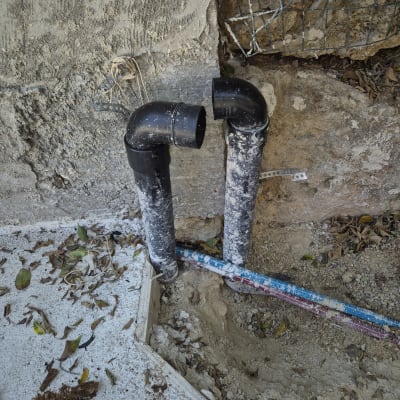 צינורות פלסטיק שחורים מותקנים בקיר בטון