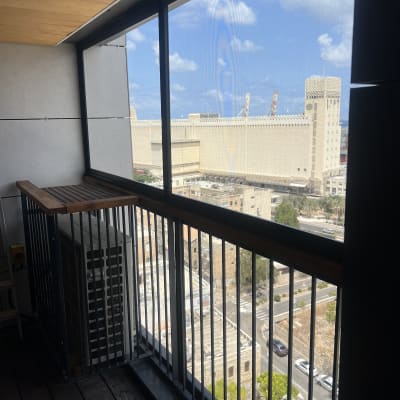 מרפסת עם מעקה מתכת ונוף לעיר