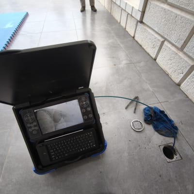 מכשיר בדיקה ליד פתח ניקוז על רצפה