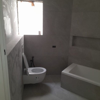 Bathroom under renovation with toilet and bathtub installed