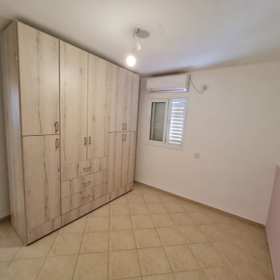 חדר עם ארון עץ וקיר צבוע חלקית