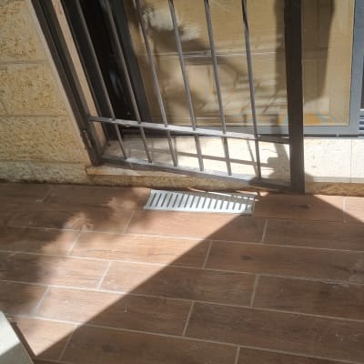 פתח ניקוז ברצפה ליד דלת מתכת