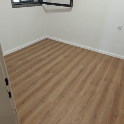 רצפת פרקט בחדר ריק עם חלון פתוח