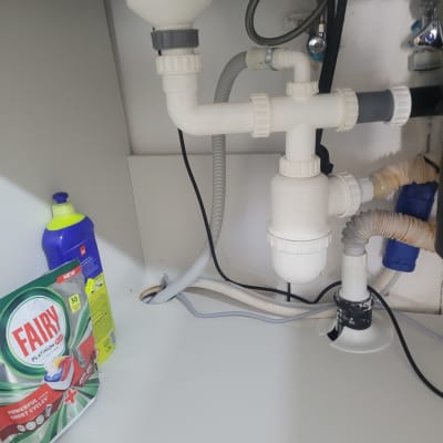 צנרת מתחת לכיור עם חומרי ניקוי