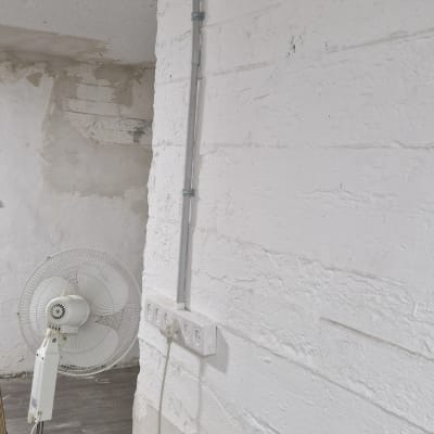 שקעי חשמל על קיר עם מאוורר עומד