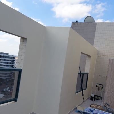 קיר צבוע בצבע בהיר עם כלי צביעה על הרצפה