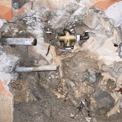 צנרת חשופה בקיר עם חיבורים ותיקונים