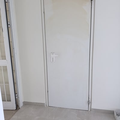 דלת לבנה עם ידית וחלק תחתון שבור