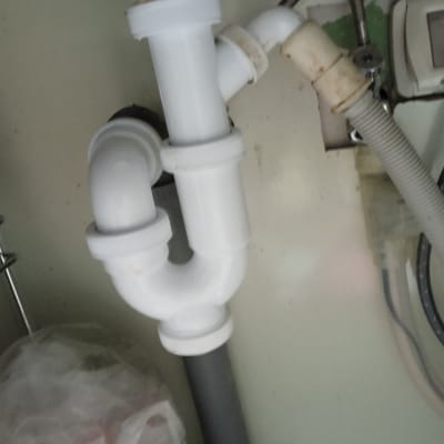 צנרת פלסטיק לבנה מתחת לכיור עם חיבורים