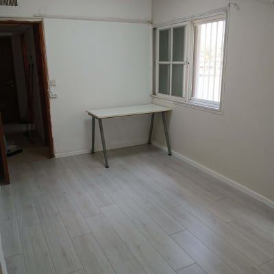 רצפת פרקט עץ בהירה בחדר ריק עם שולחן קטן