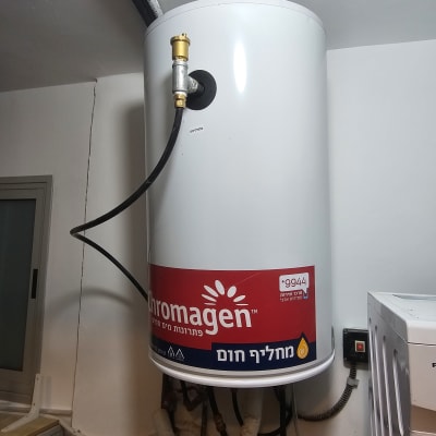 דוד שמש מותקן על קיר עם צינורות וחיבורים