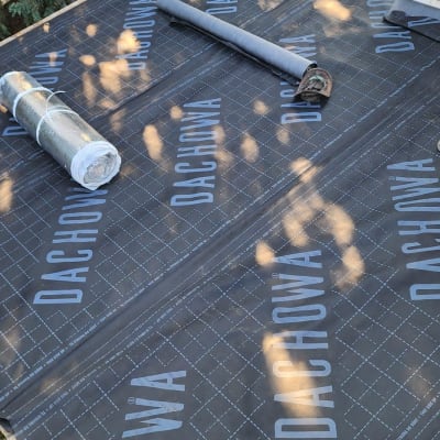 גג עם יריעות איטום ושני גלילים מונחים עליו