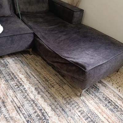 ספה וכורסה על שטיח מעוצב בחדר מגורים