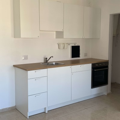 מטבח חדש עם ארונות לבנים וכיור נירוסטה
