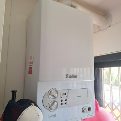 דוד חימום גז מותקן על קיר עם כובע לידו